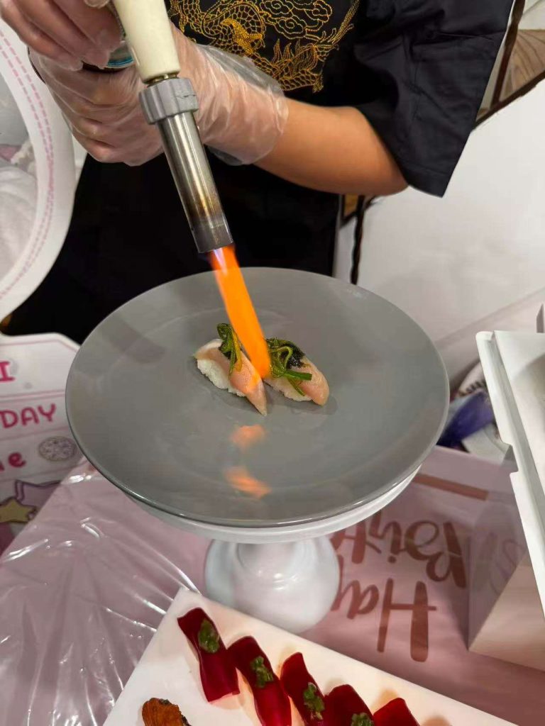 NYC private sushi chef torch-searing nigiri at a private birthday party